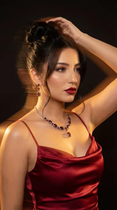 Fashion spread of a deep red satin evening gown under shifting light and shadow