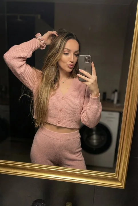 High-end pink mirror self-portrait under warm, dim lighting