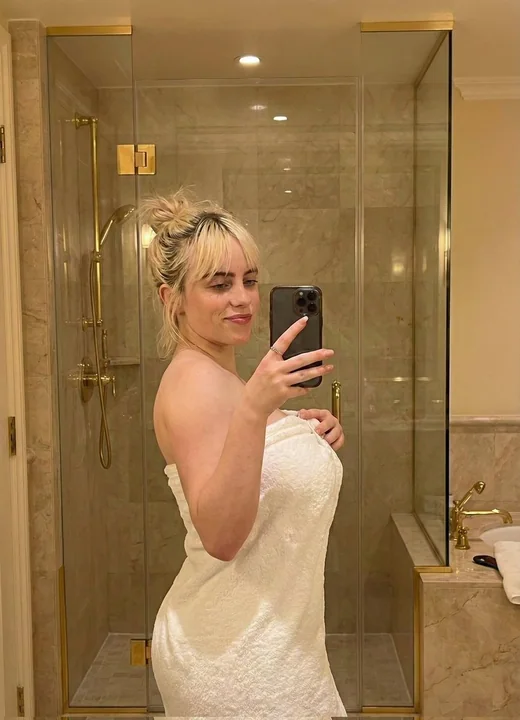 شقراء فخمة تلتقط صورة لأنفاسها أمام المرآة في حمام فاخر