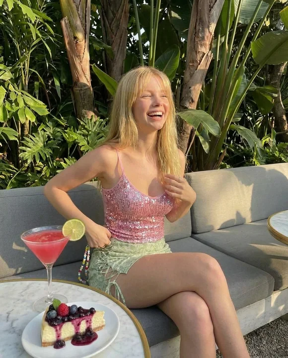 فتاة ذهبية ترتدي ملابس مشرقة في غروب الشمس الاستوائي