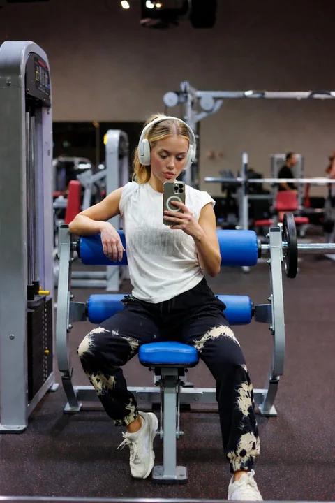 Blond girl taking a mirror selfie in the gym