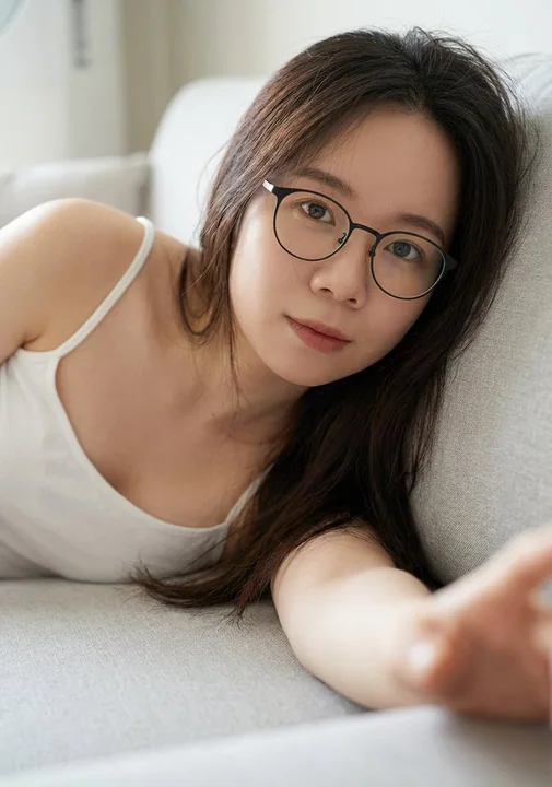 فتاة عيون لطيفة ترتدي نظارات على أريكة مريحة