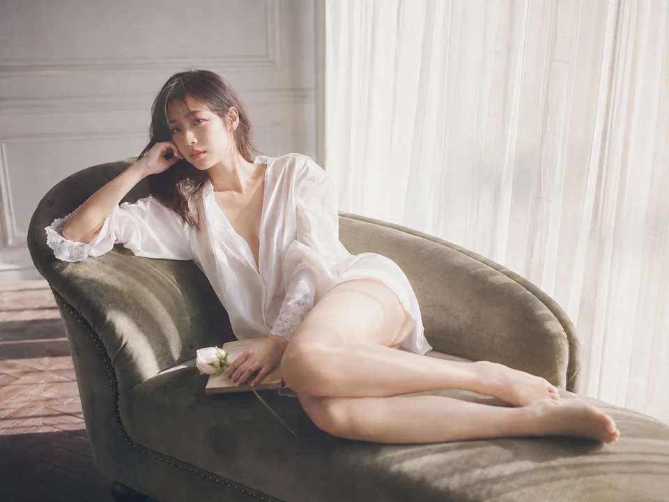 阳光窗边天鹅绒长椅上的东亚女性人像