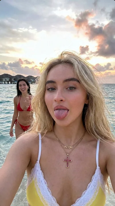 فتاة شقراء على شاطئ ماليديف مع دوا لипا تلتقط صورة تلقائية ممتعة