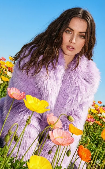 A fashion editorial featuring purple fur amidst a dazzling sea of poppies