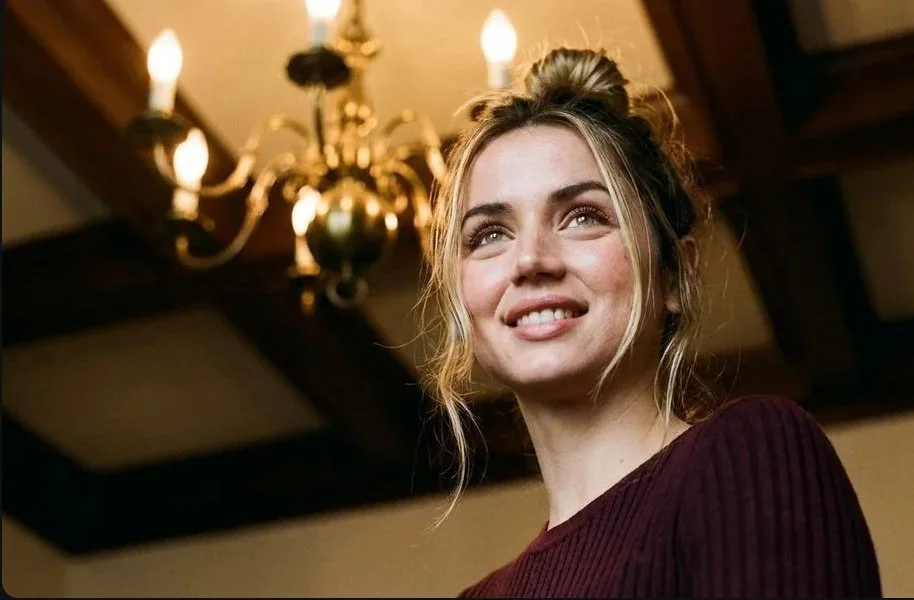 An absolutely stunning portrait shot from an extremely low upward angle under the warm light of a vintage chandelier