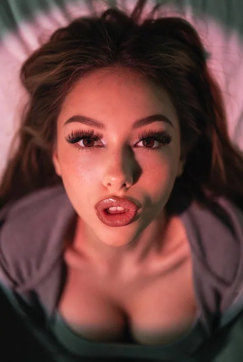 An intimate, atmospheric editorial shot of a Y2K baddie under high-angle flash.
