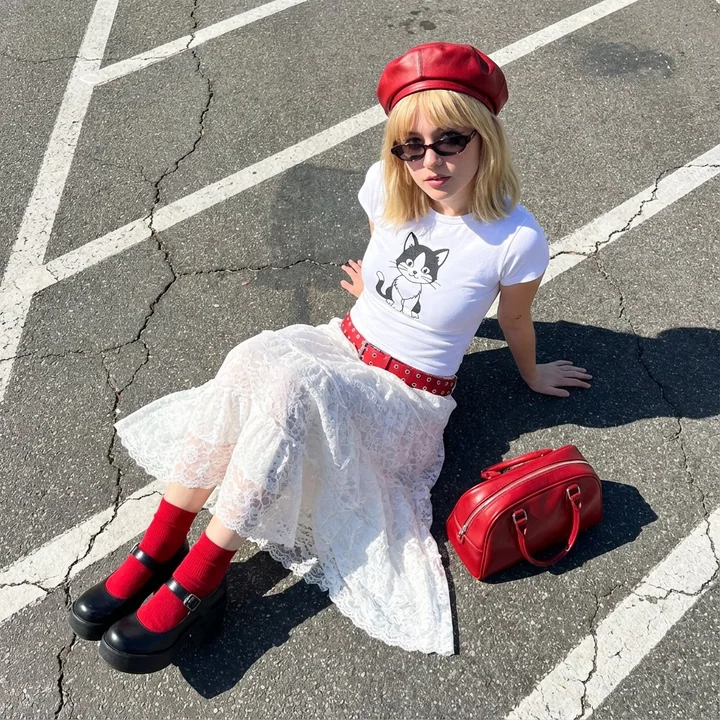 赤いベレー帽をかぶった金髪の少女のモダンなストリートファッション